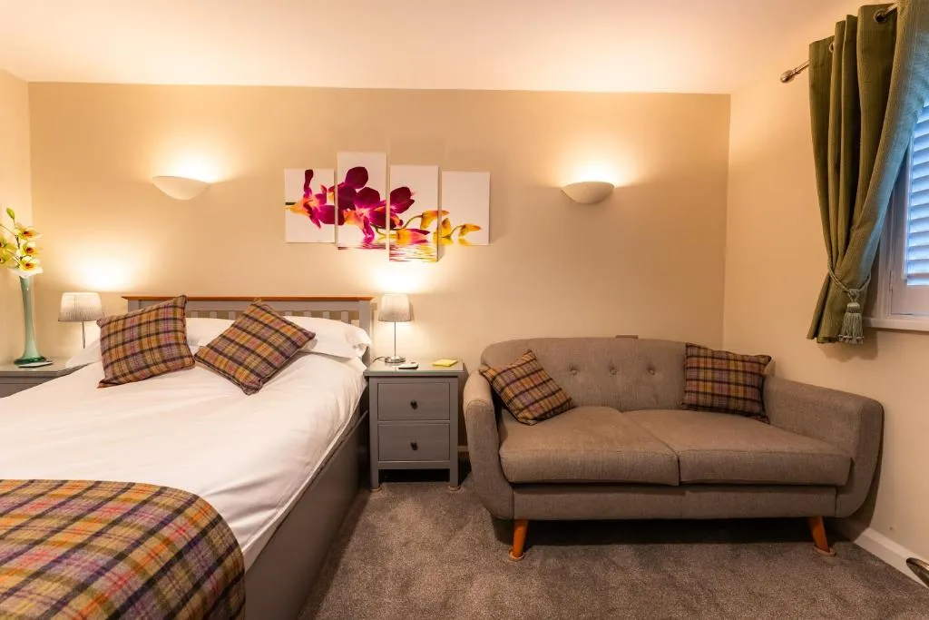 Comfortable luxury bedroom with warm lighting and seating at Blueberry Lets